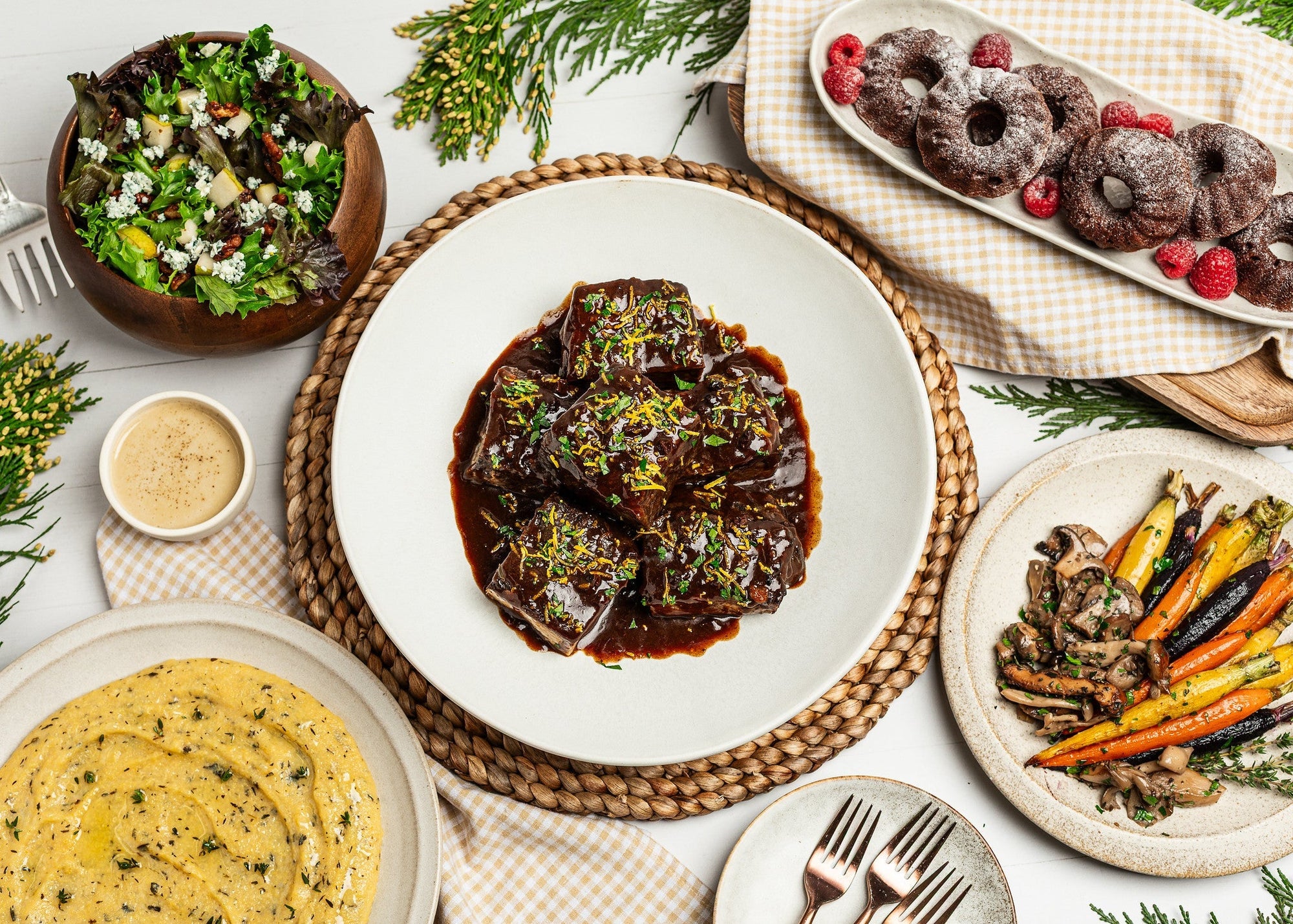 Gourmondo holiday spread including roasted veggies, mashed potatoes. glazed short ribs, side salad, and mini chocolate bundt cakes. 