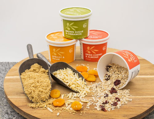 Circular wooden board with a variety oatmeal cups spilling out