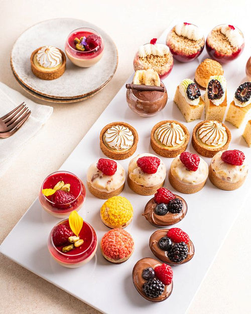 Platter of mini desserts including tarts,  cakes, and mini cups