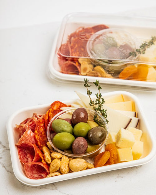 Individual tray with assorted cheeses, cured meats, olives, Marcona almonds, and dried fruit