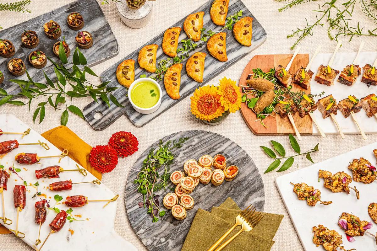 Assorted spring appetizers including rolls, empanadas, and skewers