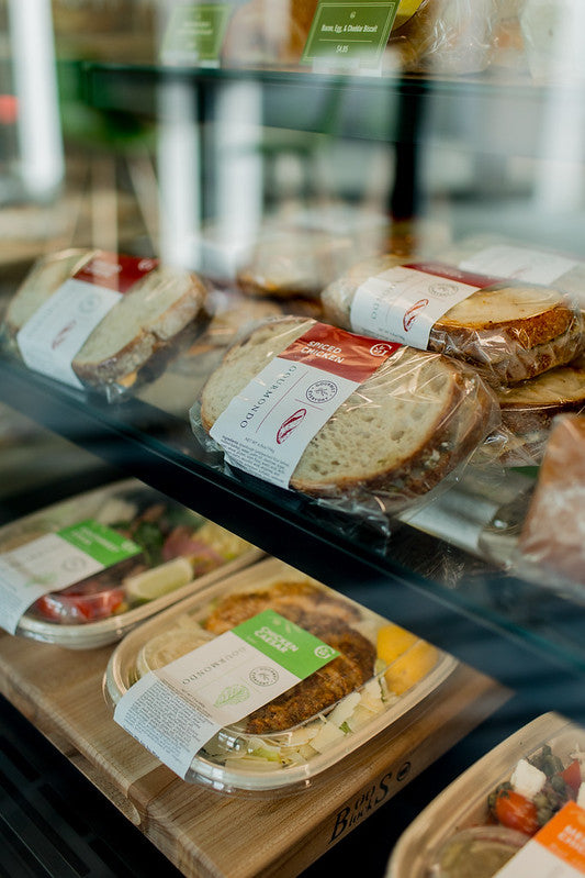 Case of Gourmondo items including salads and bowls, sandwiches, and baked goods