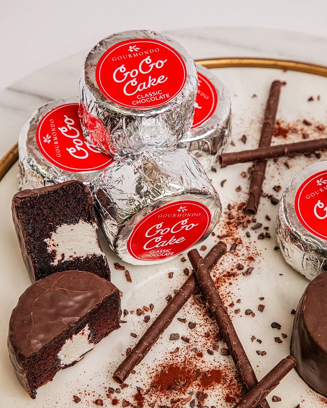 Mini chocolate cakes with creamy filling, both wrapped in foil and unwrapped and cut