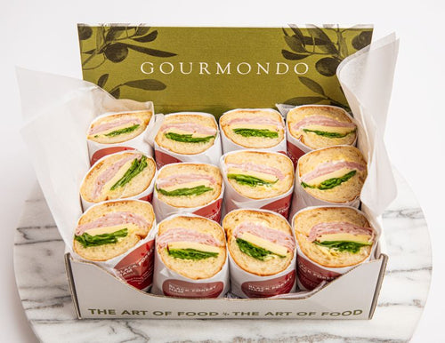 box of sandwich halves with ham, cheese, and lettuce on baguette