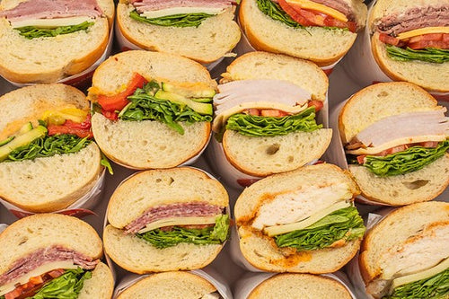 Box of sandwich halves on baguette: including chicken, veggie, turkey, beef, and ham