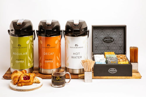 Pump pots of regular, decaf, and hot water, with assorted tea bags and coffee condiments in a box 
