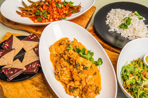 Package meal of chana masala, tofu tikka masala, basmati rice, mixed greens salad, and rose-chai cookies 