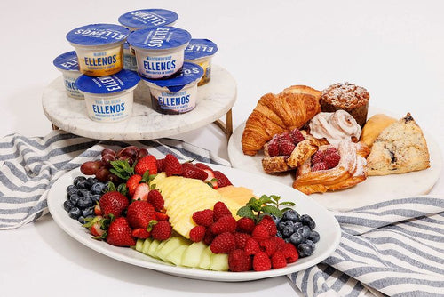 Package breakfast meal with Ellenos yogurt cups, platter of cut fruit and berries, and assorted pastries