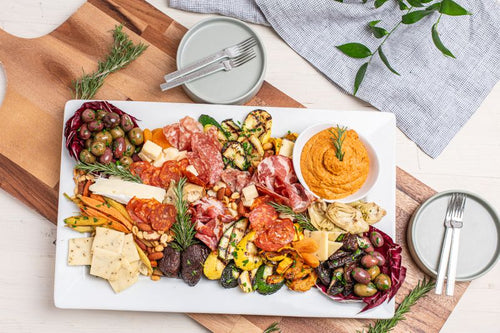 Platter with assorted cured meats,, roasted veggies, cheeses, muhammara sauce, and olives