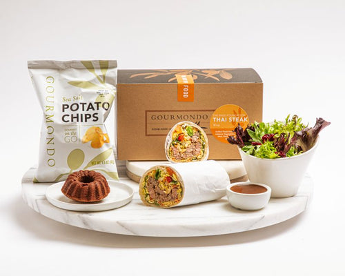 Boxed lunch including wrap, mixed greens salad, potato chips, and mini chocolate dessert