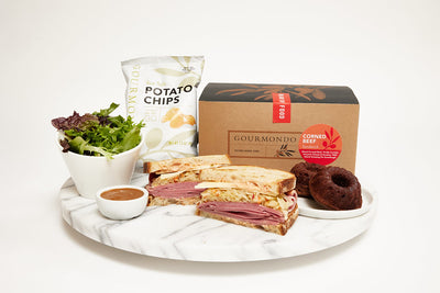 Classic corned beef sandwich in a box lunch with chips, bundt cake, and side salad