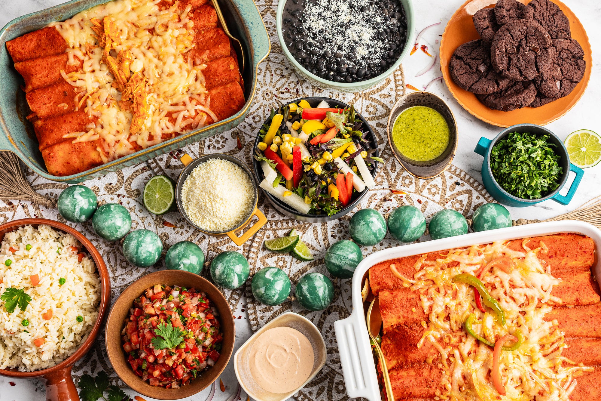 Package meal including enchiladas, black beans, jicama salad, assorted salsas, and Mexican rice with chocolate cookies