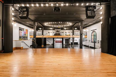 Large indoor space with high ceilings, wooden floor, and multiple levels.