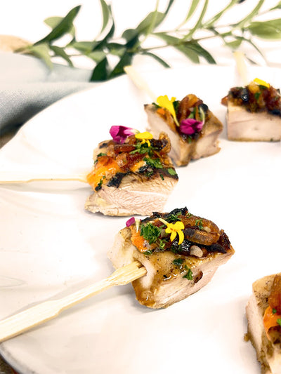 Skewer with chicken, southern sauce, and edible flowers