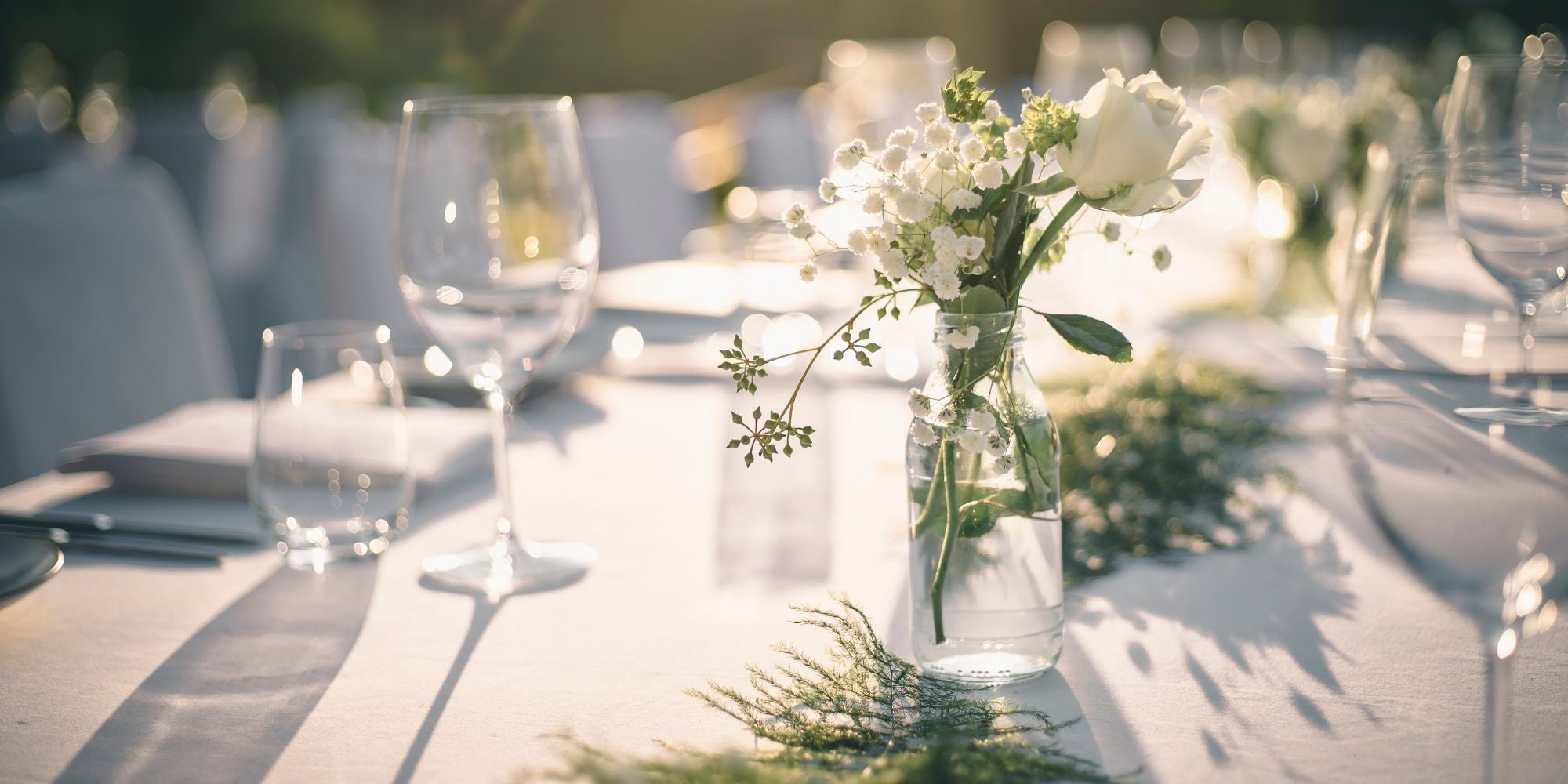Floral centerpiece in wedding table settings with goblets and wine glasses